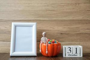 pumpkin bowl of candy, 31 October calendar and frame with copy space for text. Happy Halloween day, Hello October, fall autumn season, Festive, party and holiday concept photo