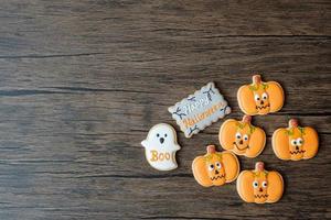 feliz día de halloween con galletas divertidas sobre fondo de mesa de madera. truco o amenaza, hola octubre, otoño otoño, festivo, fiesta y concepto de vacaciones foto