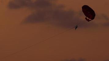 parachute ascensionnel sur la plage de karon au coucher du soleil, phuket, thaïlande video