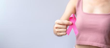 Pink October Breast Cancer Awareness month, woman hand hold pink Ribbon and wear shirt for support people life and illness. National cancer survivors month, Mother and World cancer day concept photo