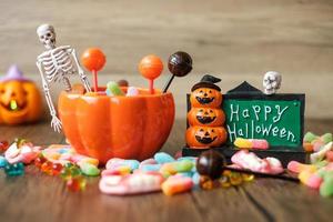 feliz día de halloween con dulces fantasmas, tazón de calabaza, jack o linterna y decorativos. truco o amenaza, hola octubre, otoño otoño, festivo, fiesta y concepto de vacaciones foto