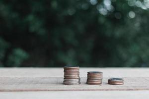 las monedas se colocan en tablones de madera al aire libre en el jardín, concepto de ahorro de inversión. copie el espacio. foto