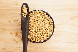 soybean in a bowl with wooden spoon on wooden background, top view, flat lay, top-down, selective focus.copy space. photo