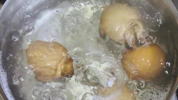 ovos de galinha são cozidos em água fervente em uma panela. video