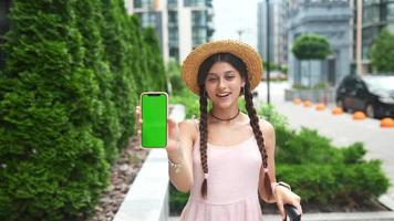 jovem mulher na moda no centro da cidade segura telefone inteligente com tela verde video