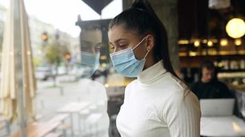 Woman looking through coffee shop window video