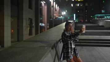 menina usando seu telefone na cidade à noite video