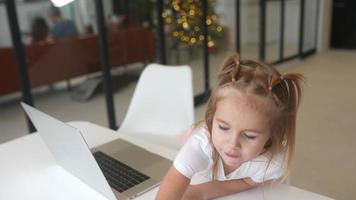 Little girl using computer at home with family video