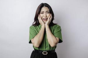 Young Asian woman isolated on white background face covered by fingers frightened and nervous. photo