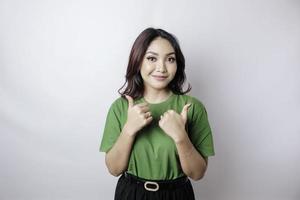 Excited Asian woman gives thumbs up hand gesture of approval, isolated by white background photo