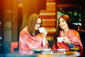 dos chicas jóvenes y hermosas cotilleando foto