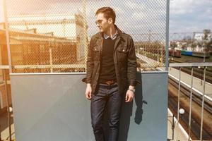 un hombre vestido con jeans en el fondo del tren y la estación foto