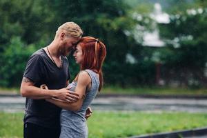 beautiful couple hugging in the rain photo