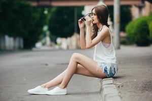 pretty girl sitting in a city street photo