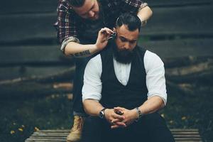 barbero afeita a un hombre barbudo