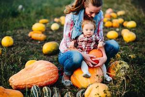 madre e hija sentadas en calabazas foto