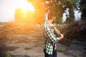 The man in the authentic boots and selvedge jeans  on a the background of branches photo