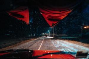 en la vista del coche de la tormenta de nieve en la carretera del campo foto