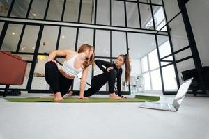 Two charming sports women, do yoga poses, exercises at home photo