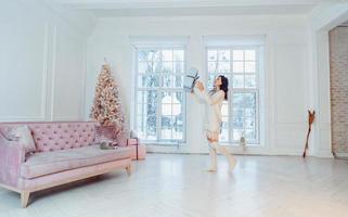 Beautiful young girl in white dress posing on camera. Christmas concept photo