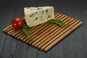 Blue cheese on wooden board and wooden background photo