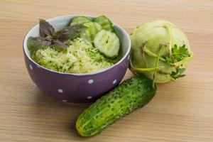 Kohlrabi salad in a bowl on wooden background photo