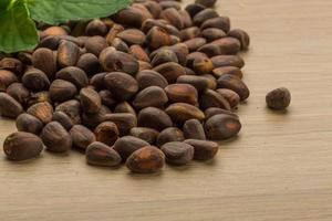 Cedar nuts on wooden background photo