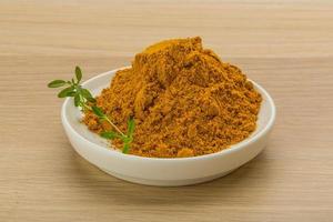 Curry powder on wooden background photo