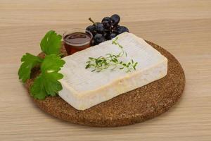 Brie cheese on wooden board and wooden background photo