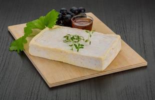 Brie cheese on wooden board and wooden background photo