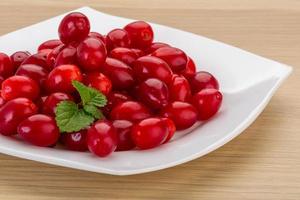 Cornus on the plate and wooden background photo