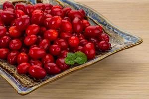 Cornus on the plate and wooden background photo