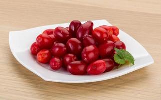 Cornus on the plate and wooden background photo