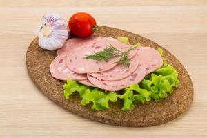 Beef sausage on wooden board and wooden background photo