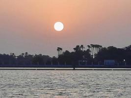 Beautiful sunset at Jeddah, Corniche. The Jeddah Corniche, also known as the Jeddah Waterfront, is a coastal area of the city of Jeddah, Saudi Arabia. Located along the Red Sea. photo