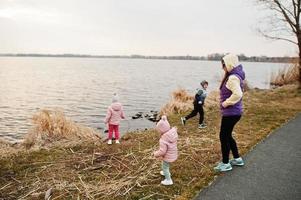 Mother with kids on the shore of the lake. photo