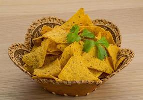 Nachos in a basket on wooden background photo