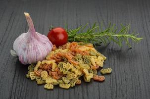 Colored pasta on wooden background photo