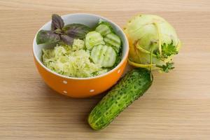 Kohlrabi salad in a bowl on wooden background photo