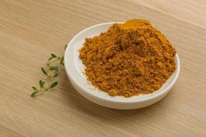 Curry powder on wooden background photo