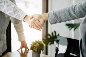 Businesswoman handshake for teamwork of business merger and acquisition,successful negotiate,hand shake,two business woman shake hand with partner to celebration partnership and business deal concept. photo