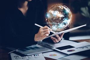 Business woman using a tablet to work through the internet technology for the digital marketing era, data analysis, metaverse, big data, Business global internet, global network and data exchanges. photo