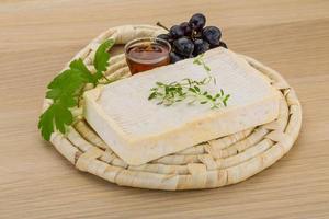 Brie cheese on wooden board and wooden background photo