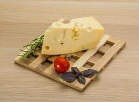 Maasdam cheese on wooden board and wooden background photo