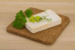 Brie cheese on wooden board and wooden background photo