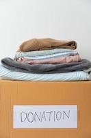 Clothing donation, Sharing, Hope concept. Used clothes on the carton donation box preparing to others photo