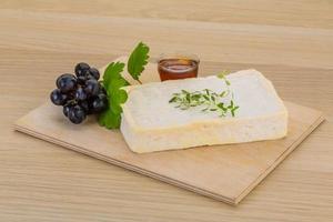 Brie cheese on wooden board and wooden background photo