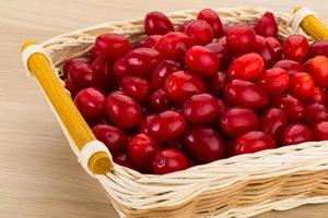 Cornus in a basket on wooden background photo