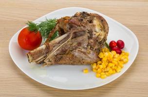 Roasted turkey leg on the plate and wooden background photo