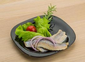 Herring fillet on the plate and wooden background photo